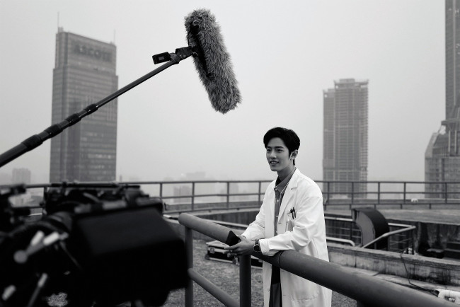 Обои картинки фото мужчины, xiao zhan, актер, халат, телефон, крыша, камера, съемки