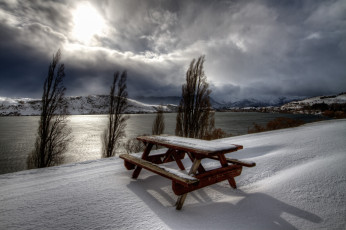 обоя природа, зима, вода, скамейка, солнце, река, столик, деревья, снег, горы, тучи