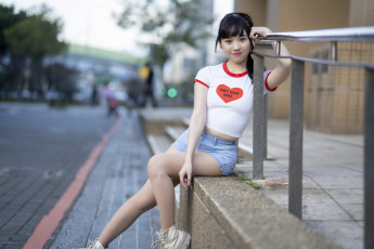 Картинка девушки -unsort+ азиатки модель улица перила сидит джинсовые шорты футболка карие глаза красная помада улыбается взгляд на зрителя челка брюнетка