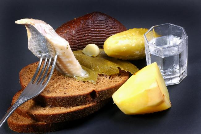 Обои картинки фото еда, натюрморт, хлеб, рюмка, селедка, огурец, рыба, чёрный, маринованный, напиток, вилка, стопка, водка, сельдь, картофель