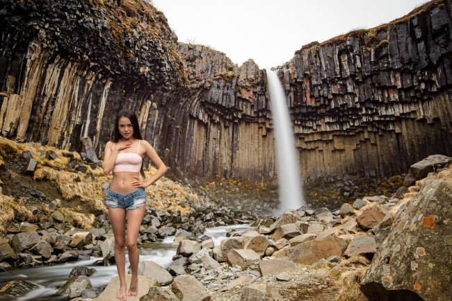 Обои картинки фото девушки, li moon, камни, водопад, шорты, топ