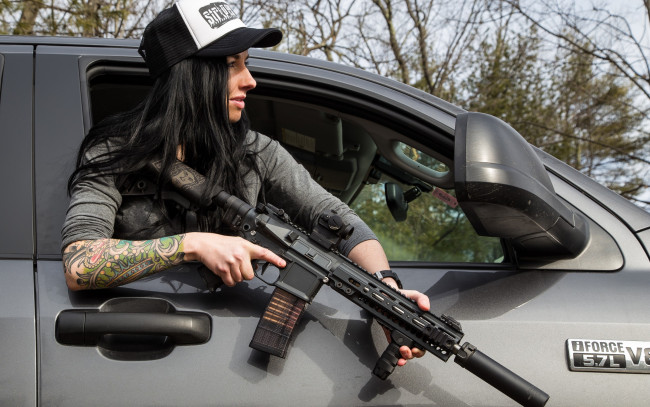 Обои картинки фото девушки, -unsort , девушки с оружием, кепка, лицо, штурмовая, винтовка, автомобиль, тату, рука, волосы, девушка