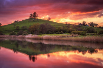 Картинка природа восходы закаты домики небо трава река закат холм деревья вода отражение