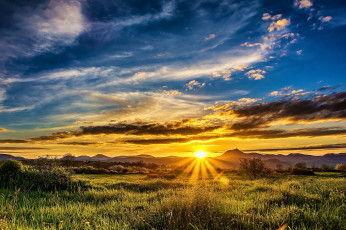 Картинка природа восходы закаты закат горы лучи солнца небо трава зелень облака поле