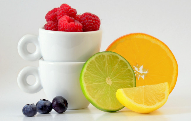 Обои картинки фото еда, фрукты,  ягоды, лимон, лайм, апельсин, малина, дольки, цитрусы, чашки, ягоды, голубика