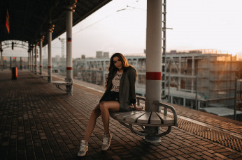 Картинка девушки -unsort+ брюнетки темноволосые улыбаясь кроссовки сидя железнодорожный вокзал джинсовые шорты портрет