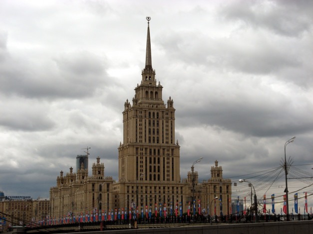 Обои картинки фото города, москва, россия, тучи, фонарные, столбы, флаги, здание