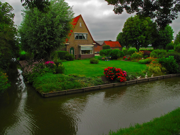 Обои картинки фото города, здания, дома, река, лужайка, дом, цветы