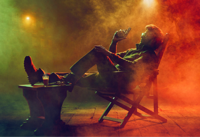 Обои картинки фото мужчины, - unsort, пистолет, актер, болливуд, кресло, стол, дым, rajinikanth, darbar