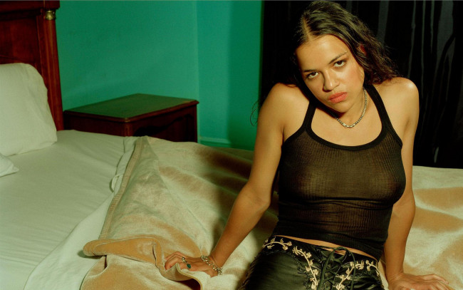 Обои картинки фото девушки, michelle rodriguez, актриса, майка, штаны, постель, взгляд