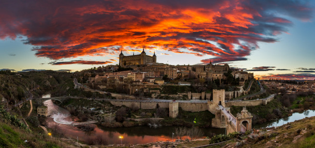 Обои картинки фото toledo under a red sky, города, толедо , испания, тучи, зарево, замок, мосты, гора, река