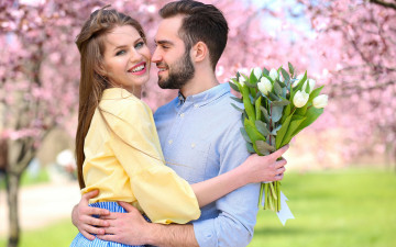 Картинка разное мужчина+женщина весна двое влюблённые цветы букет парень сад шатенка деревья белые тюльпаны цветение девушка пара боке