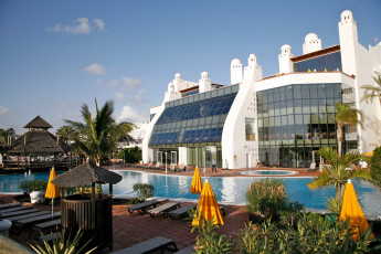 Картинка города здания дома бассейн пальмы зонтики здание
