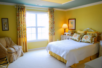 Картинка интерьер спальня кровать лампа кресло подушки желтый