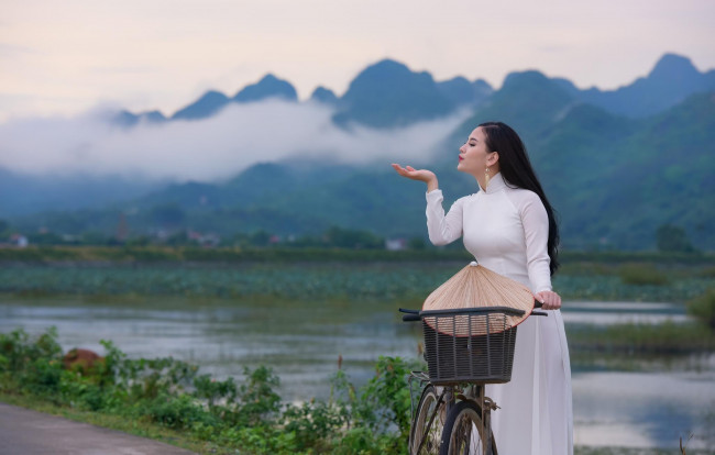 Обои картинки фото девушки, -unsort , азиатки, горы, облака, река, велосипед, шляпа