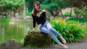 Картинка девушки -+азиатки девушка модель черный синие джинсы сидит на камне водоем деревья