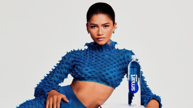 Обои картинки фото девушки, zendaya coleman, брюнетка, костюм, вода, бутылка