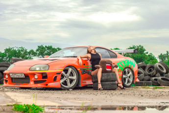 Картинка автомобили -авто+с+девушками девушка модель шатенка поза автомобиль авто оранжевый трасса ралли гоночный игрушка шины колёса флирт
