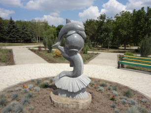 Картинка города памятники скульптуры арт объекты дельфин скульптура скамейка деревья клумба парк лавка