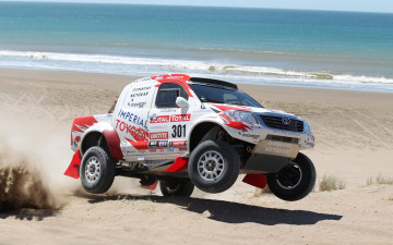 Картинка спорт авторалли волны вода дакар dakar прыжок песок берег гоночный болид передок ралли кар хайлюкс тойота