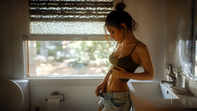 Обои картинки фото девушки, delaia gonzalez, шатенка, топ, шорты, окно, умывальник