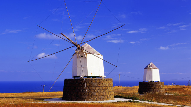 Обои картинки фото porto, santo, island, portugal, разное, мельницы, море, трава, небо, old, wind, mills, portela, madeira, ветряки