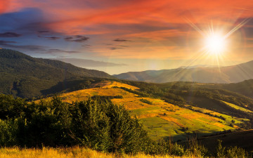 Картинка природа восходы закаты лучи горы деревья возвышенность небо солнце поля желтая трава леса осень