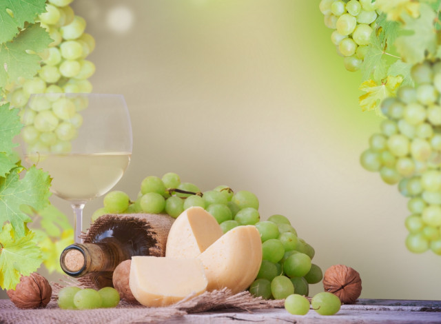 Обои картинки фото еда, напитки,  вино, стол, белое, вино, бутылка, бокал, грецкие, орехи, виноград, салфетка, листья, сыр