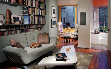 Картинка интерьер гостиная книги мольберт дизайн диван столик ваза подушки