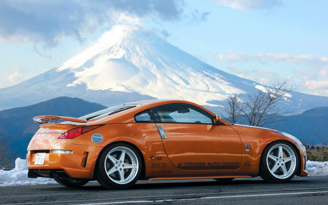 Обои картинки фото автомобили, nissan, datsun, оранжевый, дорога, снег, гора