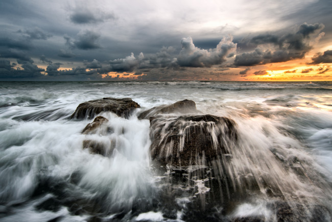 Обои картинки фото природа, побережье, океан, камни, пена, тучи, волны, зарево