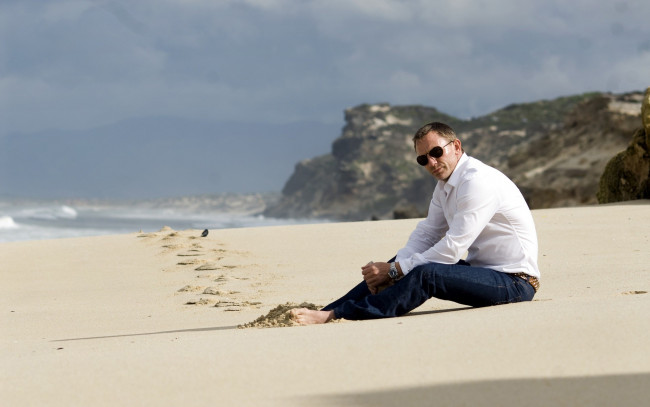 Обои картинки фото мужчины, daniel, craig, очки, песок, скалы, море