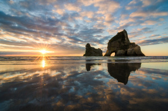 Картинка wharariki beach new zealand природа восходы закаты tasman sea тасманово море новая зеландия скалы восход отражение
