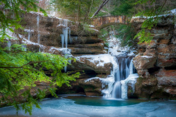 Картинка природа водопады зима снег ветки мост камни скалы водопад поток сосульки арка хвоя водоем