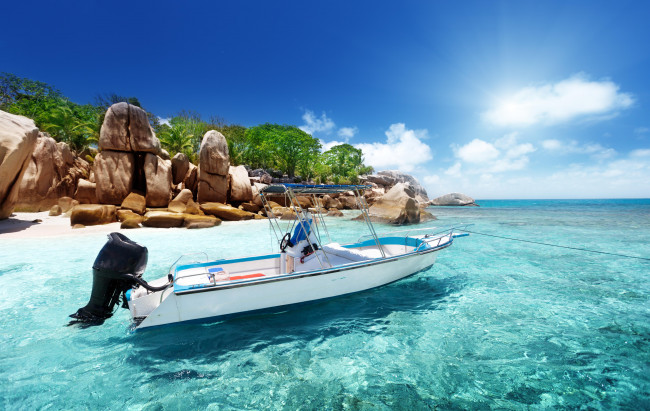 Обои картинки фото корабли, моторные лодки, сейшелы, зелень, пляж, солнце, облака, остров, скалы, песок, катер, море, небо, берег