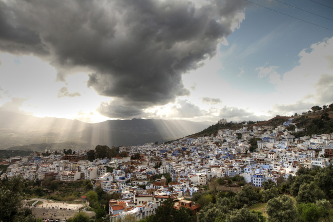 Обои картинки фото города, - панорамы, панорама, лучи, солнца, облака, небо, горы, деревья, дома, chefchaouen, марокко