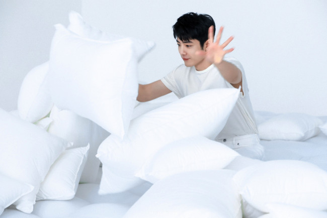 Обои картинки фото мужчины, xiao zhan, актер, футболка, кровать, подушки