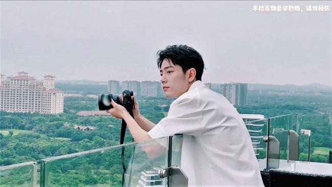 Обои картинки фото мужчины, xiao zhan, рубашка, фотоаппарат, балкон, город, панорама