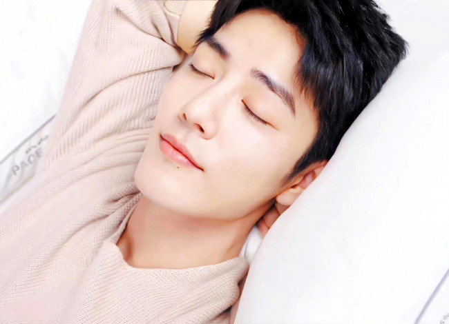 Обои картинки фото мужчины, xiao zhan, актер, свитер, постель, лицо