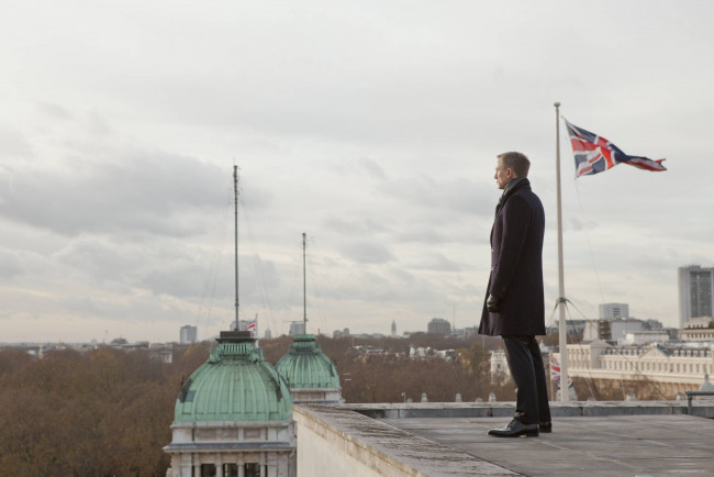 Обои картинки фото кино фильмы, 007,  skyfall, здания, флаг, крыша, пальто, джеймс, бонд