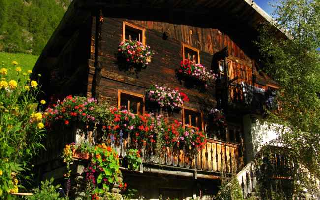 Обои картинки фото города, здания, дома, деревянный, дом, цветы, на, окнах, балконе